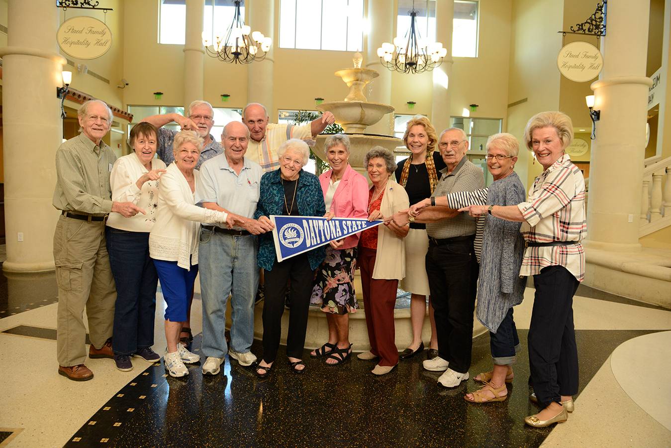 group of seniors attending WISE program event holding a Daytona State pennanten