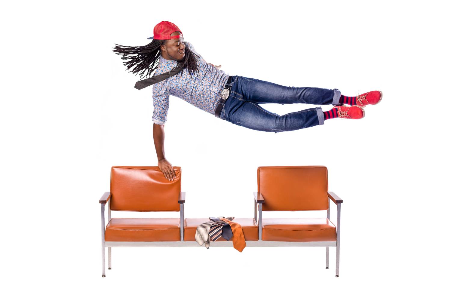 person in read backwards cap leaping sideways over a bench
