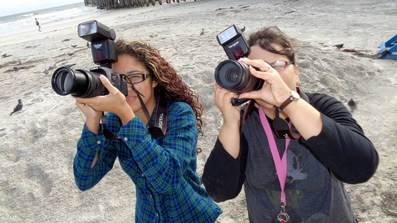 Students taking photographs outside at the beach
