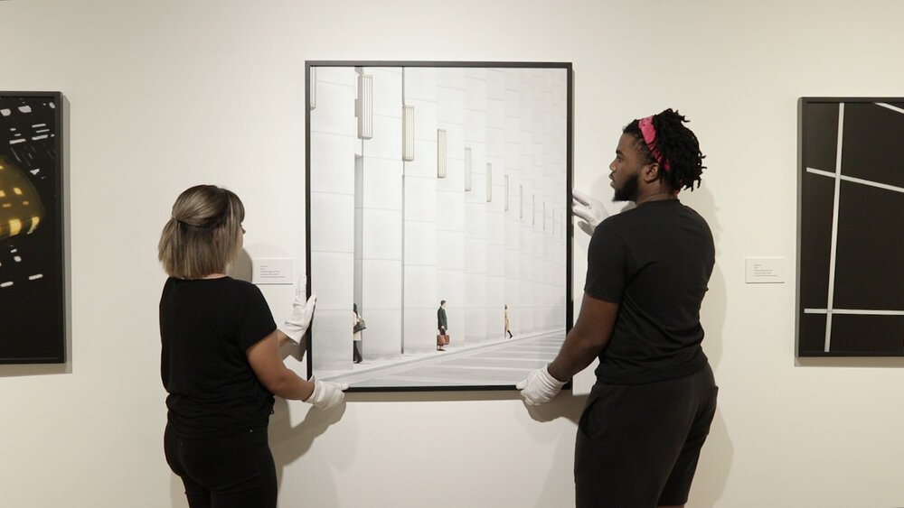two student hanging an art installation