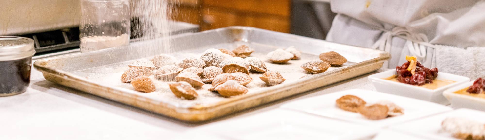 pastries being dusted with powdered sugar