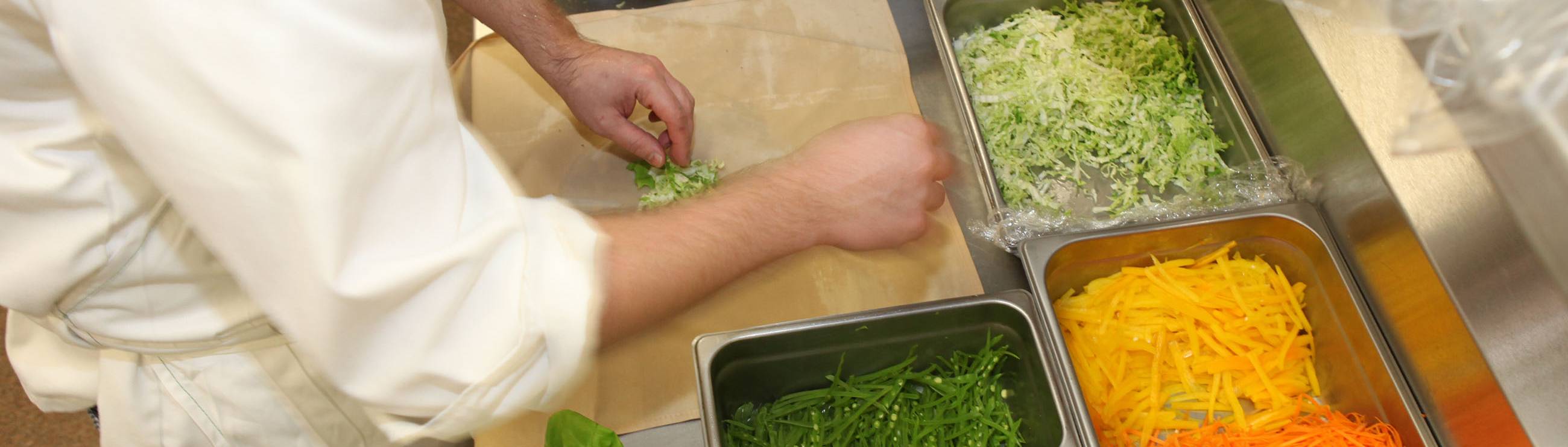 student preparing a dish with vegetables