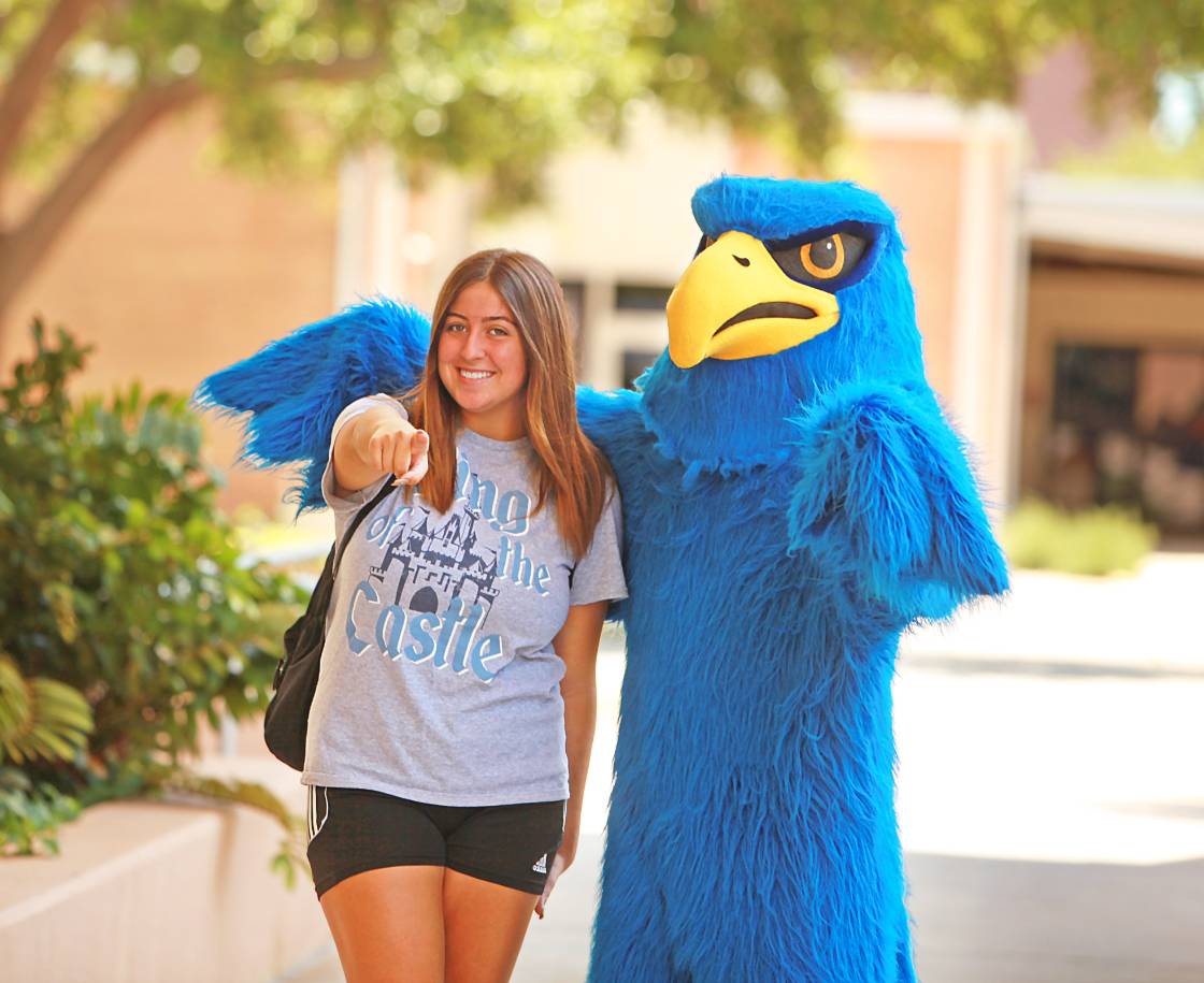 student outside with Freddie Falcon pointing