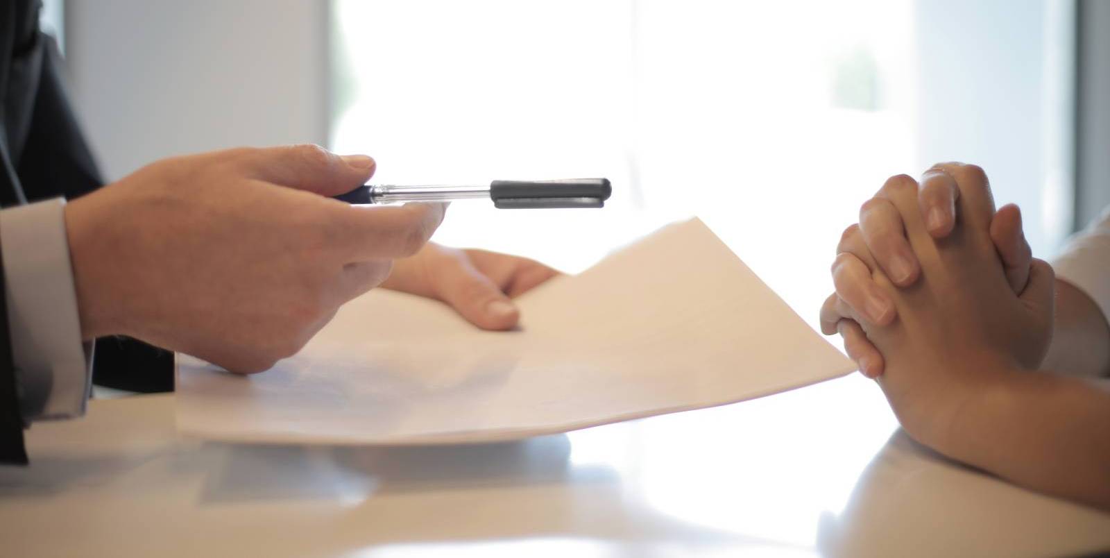 crop image of two people at table holding documents