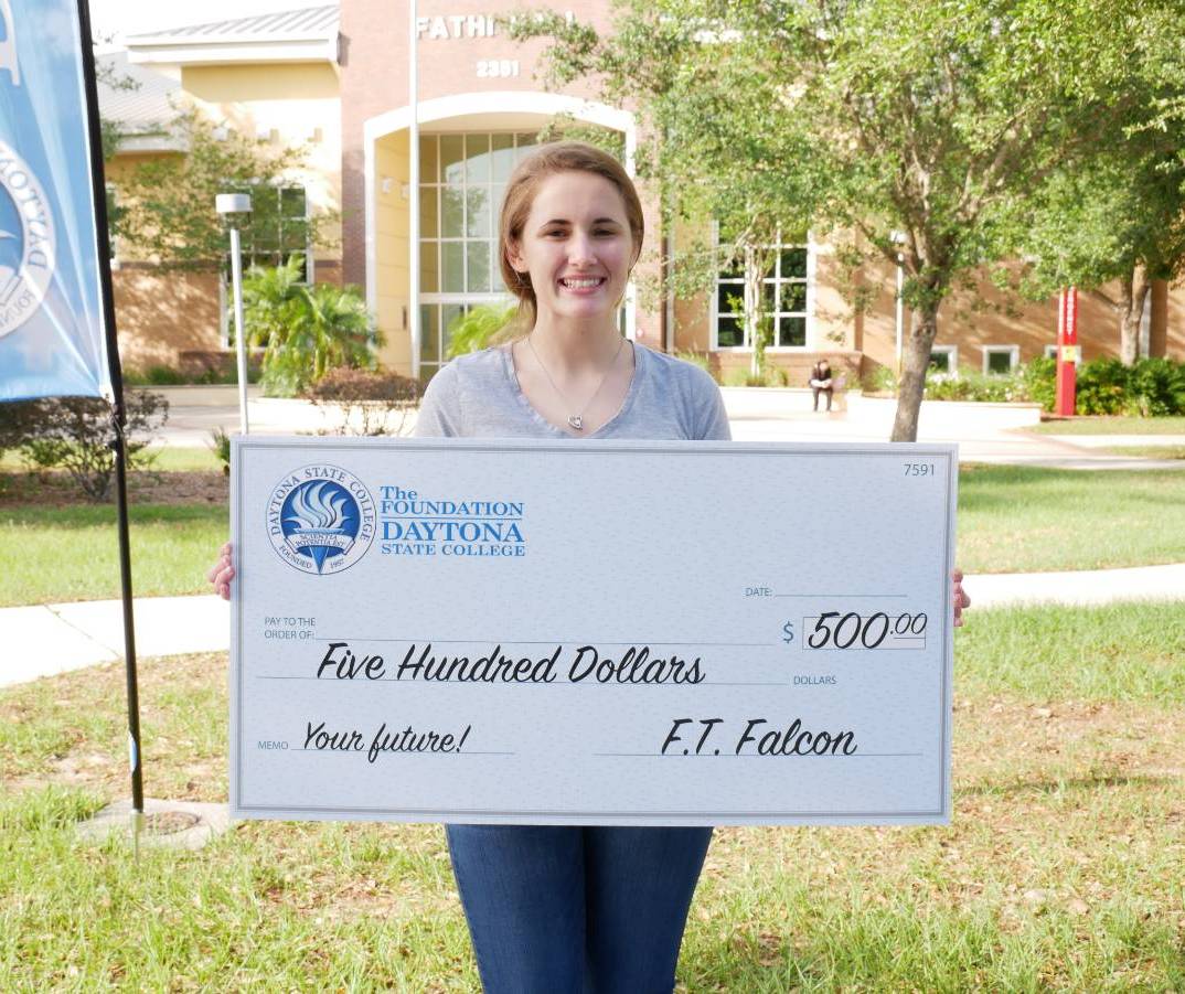 student holding a large check from the Foundation