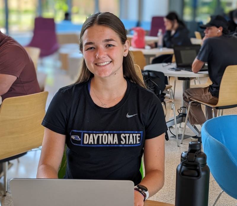 A student with a laptop in the student center. 