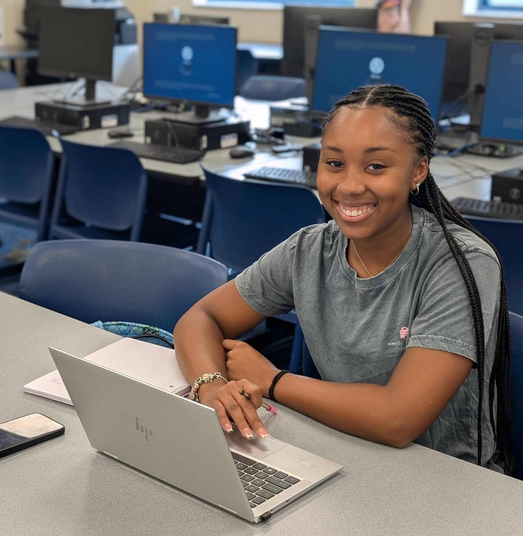 A student studying on a laptop in the library. 
