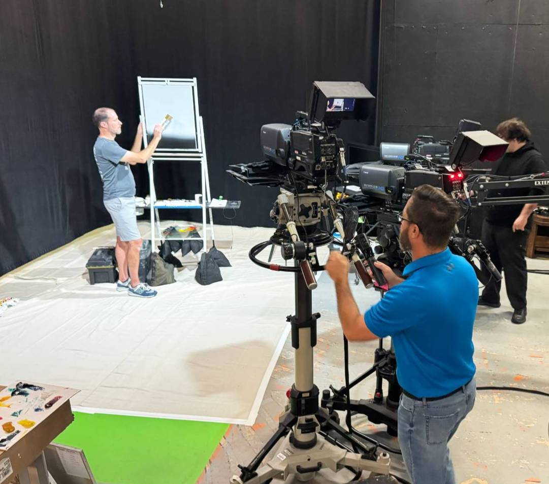 Students, staff and faculty work in the WDSC-TV 15 studio on television broadcast equipment, filming the new Bob Ross painting series. 