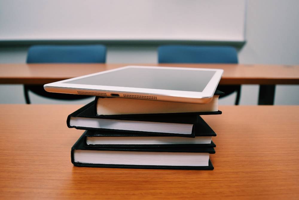 textbooks and a tablet on a desk