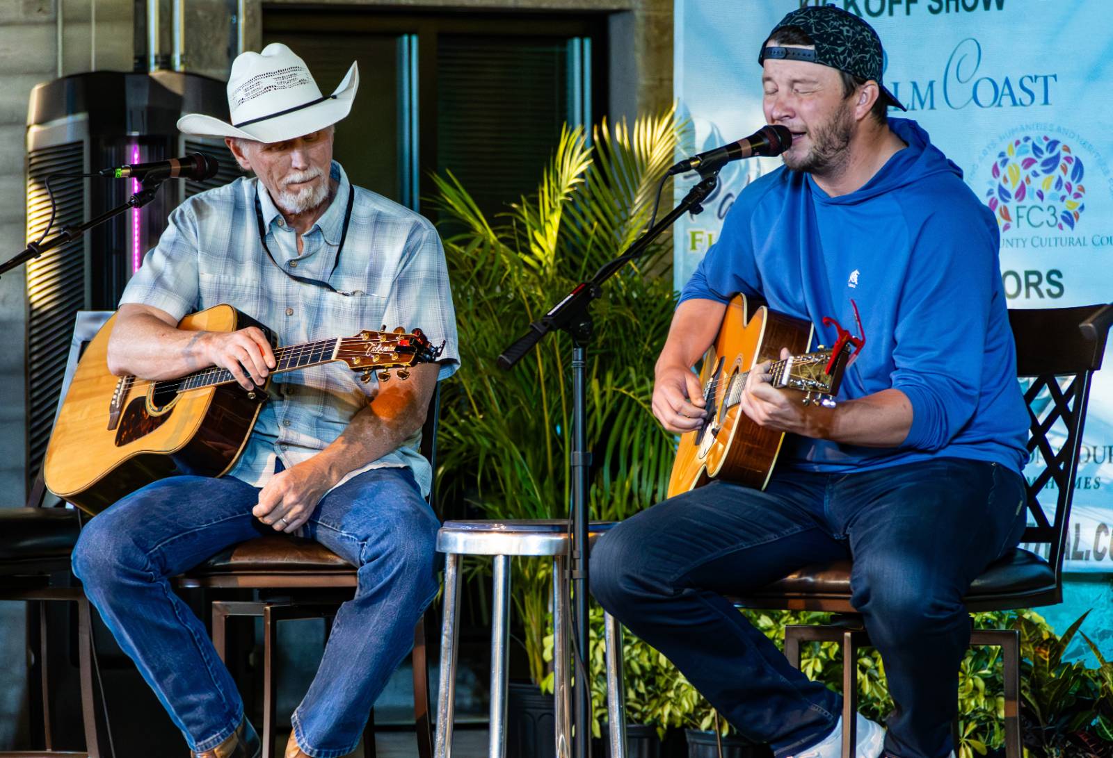 Musicians on stage singing at the Palm Coast Songwriters Festival.